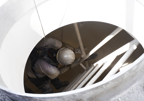 Food processing facility interior with worker: scheduled cleaning prevents listeria and contamination incidents