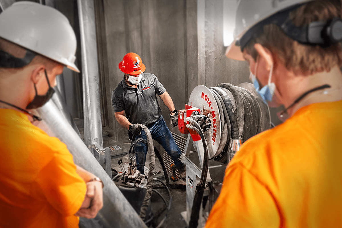 Operator running the Junior 360&deg;&reg; silo cleaning system inside a grain storage vessel